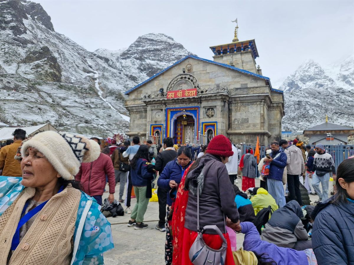 Kedarnath temple with pilgrims queuing below snow peaks
