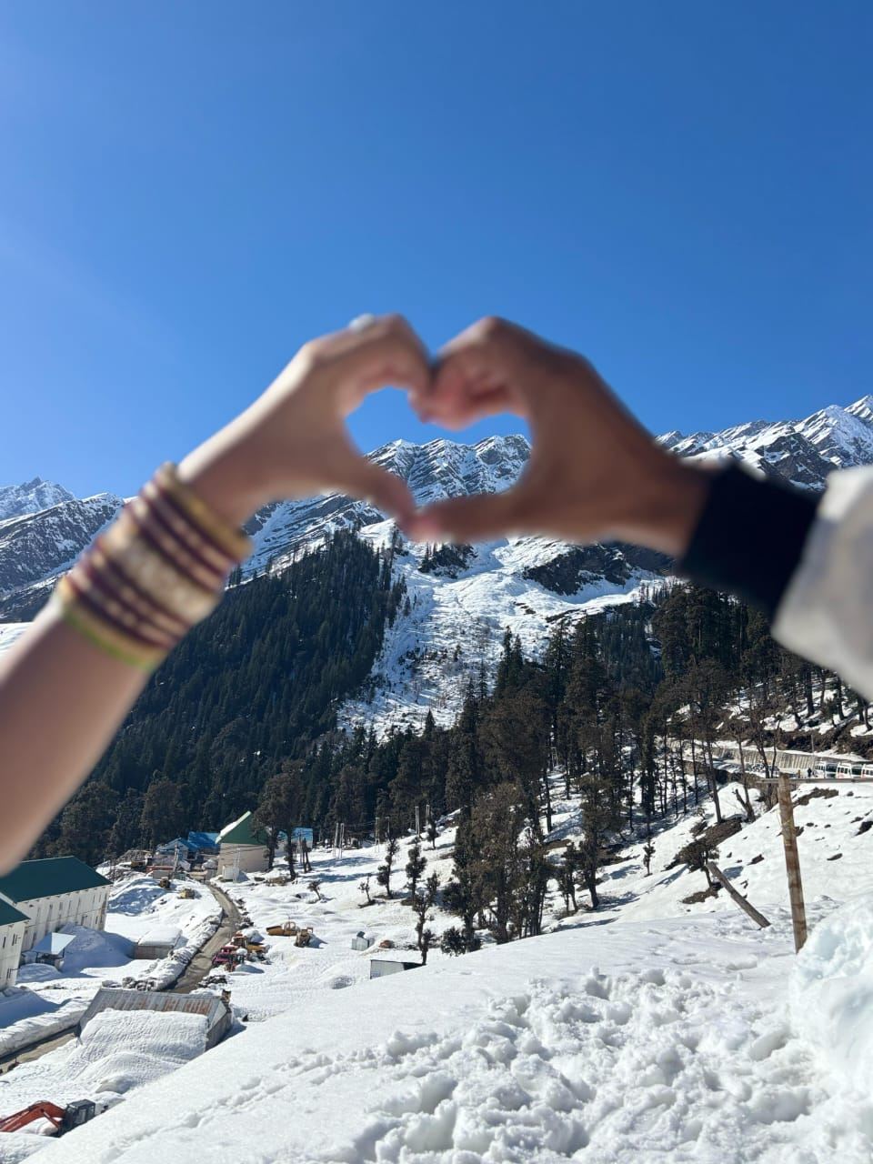 Hands making a heart shape against the snow